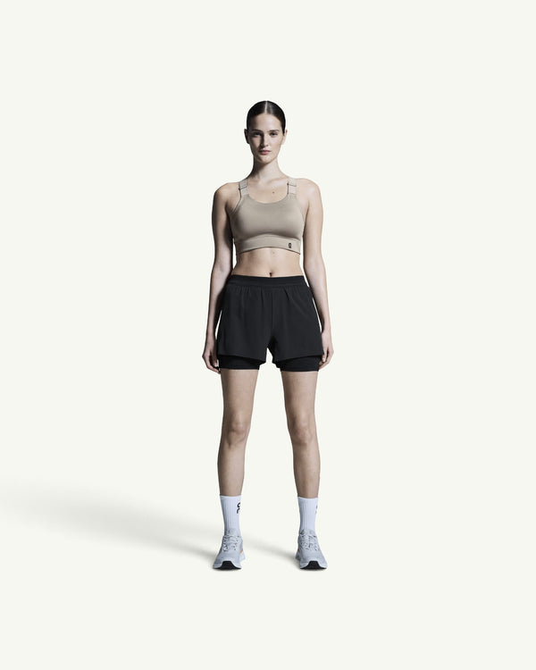 Amateur women's black 3-inch 2-in-1 performance running shorts with supportive inner tights on a model