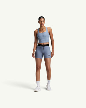 Amateur women's light blue square neck race crop top with grid pattern, worn with matching athletic shorts.