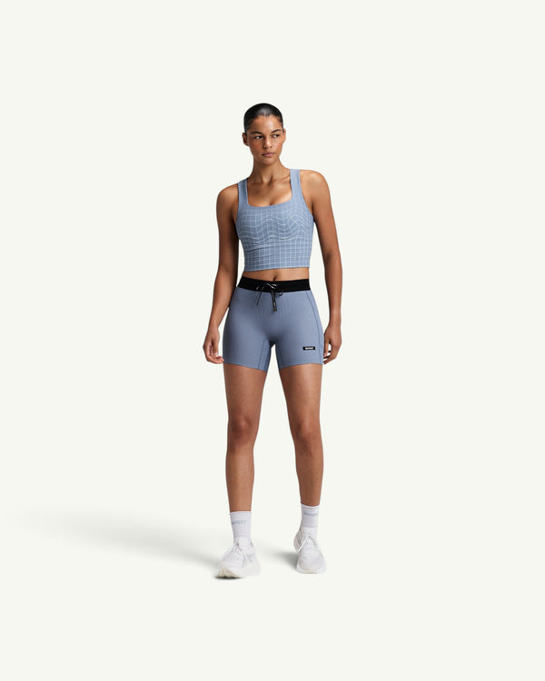 Amateur women's light blue square neck race crop top with grid pattern, worn with matching athletic shorts.