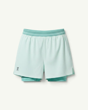Amateur women's light mint green 3-inch performance 2-in-1 running shorts with supportive inner tights.