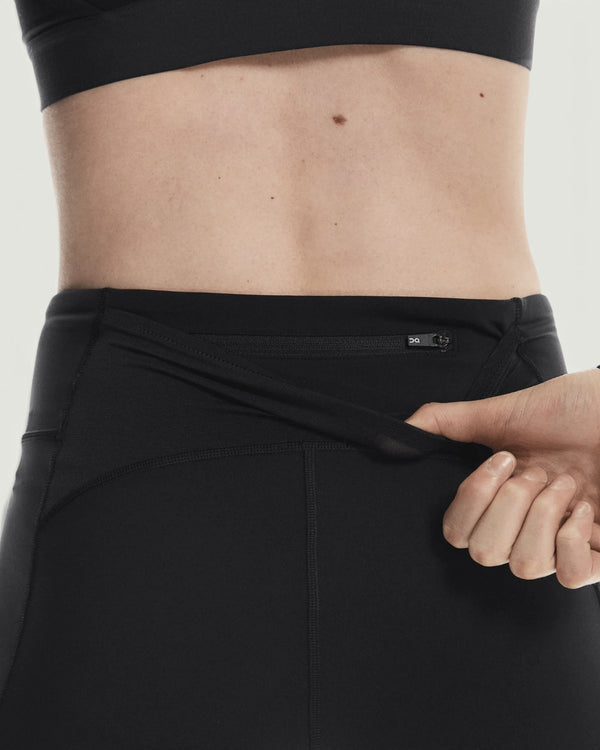Amateur women's black 3-inch performance running tights featuring a secure back zipper pocket for storage.