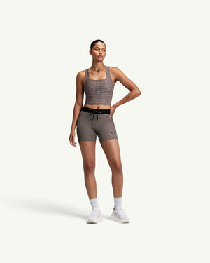 Amateur women's taupe square neck race crop top with geometric mesh detailing, worn with matching athletic shorts.