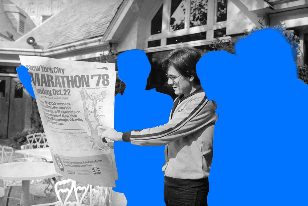 Archive photo: Fred Lebow reads the 1978 New York City Marathon poster, the people around him shown as blue silhouettes